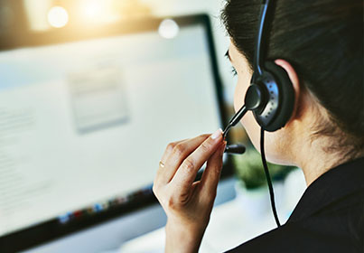 woman on headset looking at monitor