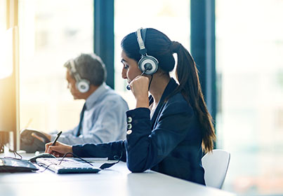 two coworkers talking on headsets